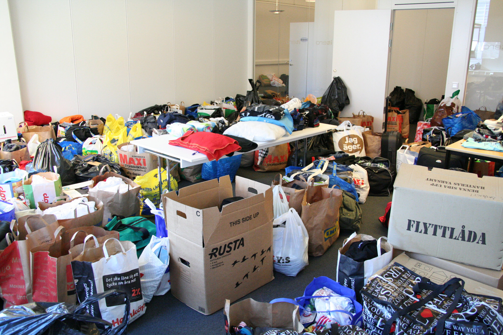 Insamling - rum fullt av kläder i kartonger och kassar